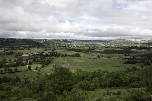 Rural landscape with green fields and hills on a cloudy day.