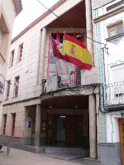 Fachada del ayuntamiento de Villamalea con banderas en el balcón.