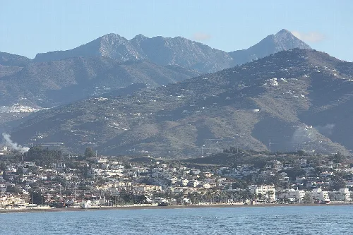 Blick auf Berge und Meer mit Gebäuden an der Küste in Torre del Mar, Málaga.
