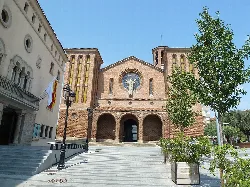 Fassade der Kirche mit Rosettenfenster und Eingang in Cornellá de Llobregat.