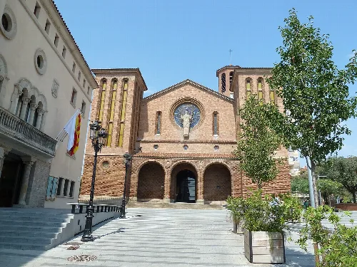Fassade der Kirche mit Rosettenfenster und Eingang in Cornellá de Llobregat.
