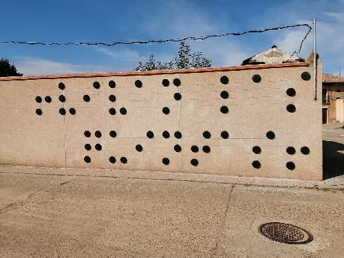 Mural en braile con puntos en una pared de Villalán de Campos