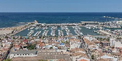 Vista aérea del puerto con embarcaderos y edificios cercanos en Denia.