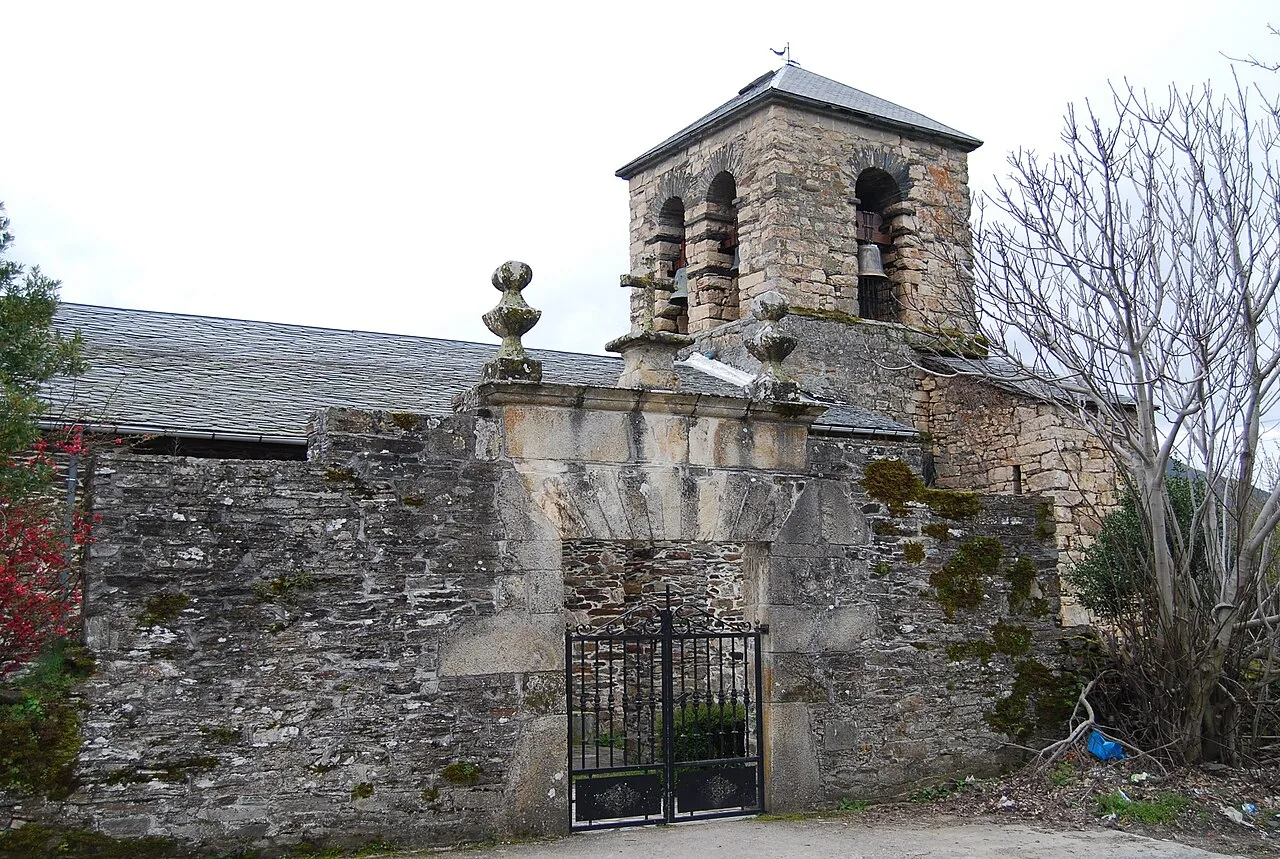 Steinige Kirche mit Turm und Eisentor in Oencia, León.