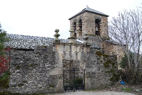 Steinige Kirche mit Turm und Eisentor in Oencia, León.