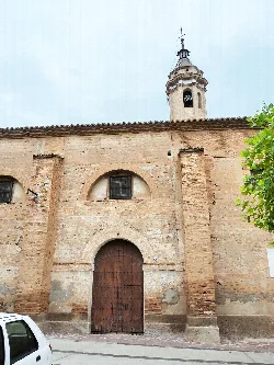 Stone church facade with tower and wooden door in Bulbuente.