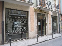 Fachada del edificio con cartel de El Faro Astorgano y ventanas grandes.