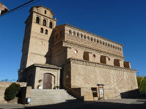 Church of Our Lady of the Assumption in Perdiguera, with tower and stone facade.