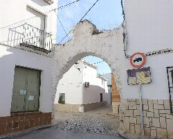 Arco de la Villa en Santa Cruz de la Zarza, con restos de estructura antigua y señal de tráfico.