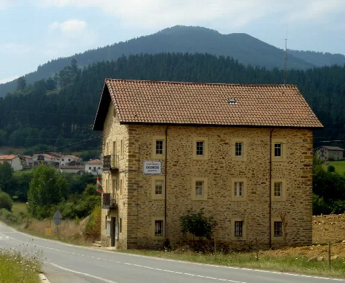 Steinernes Gebäude mit rotem Ziegeldach in Oquendo, Álava.