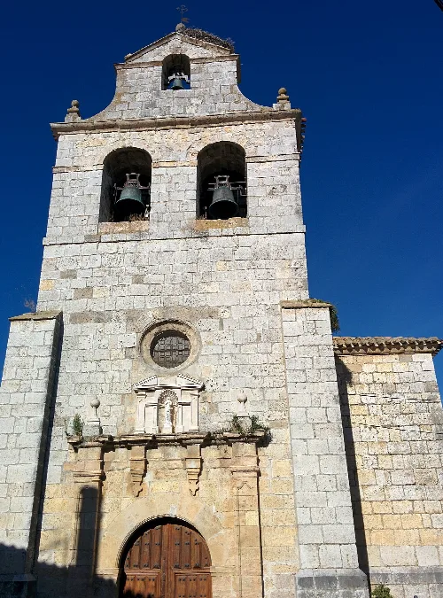 Stone tower with bells and wooden door in Villaviudas.