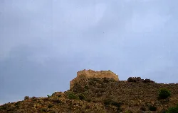 Burg auf einem Hügel in Cox, Alicante, unter bewölktem Himmel.