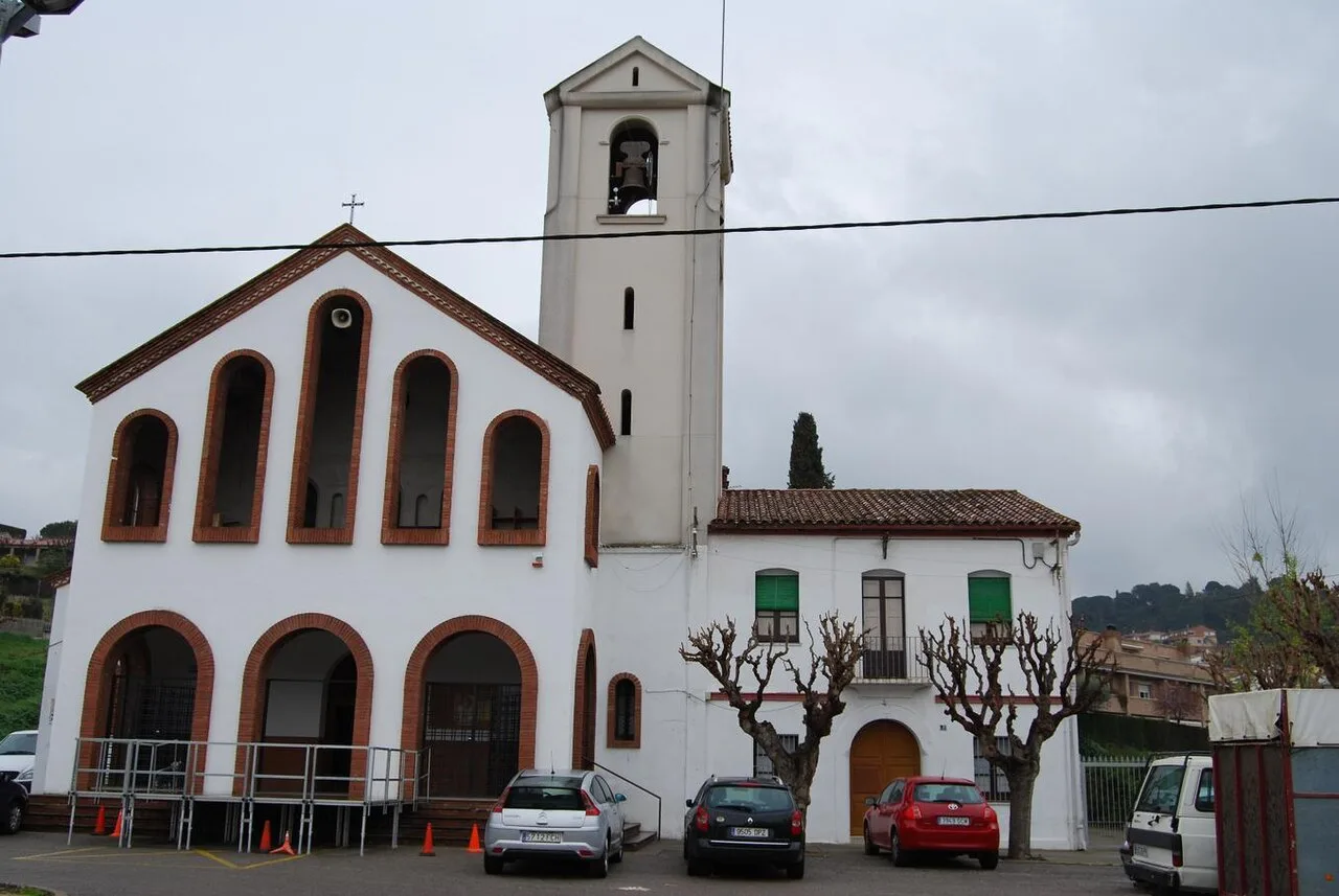 Moderne Kirche mit Turm und weißer Fassade in San Fost de Campsentelles.