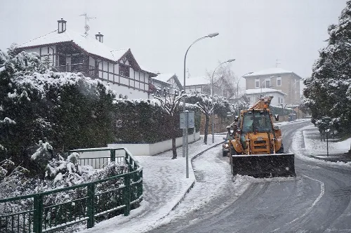 Calles nevadas en Galdácano con una máquina quitanieves en la carretera.