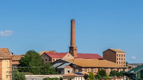 Traditionelle Gebäude und ein Industrie-Schornstein in Benalúa, Granada.