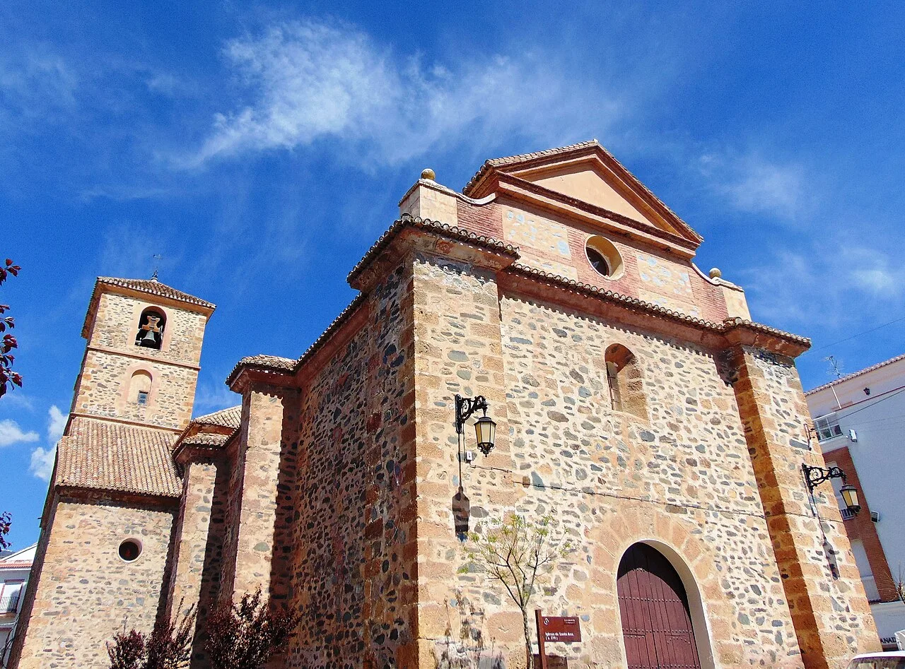 Steinernes Kirchenportal mit Turm in Cádiar.