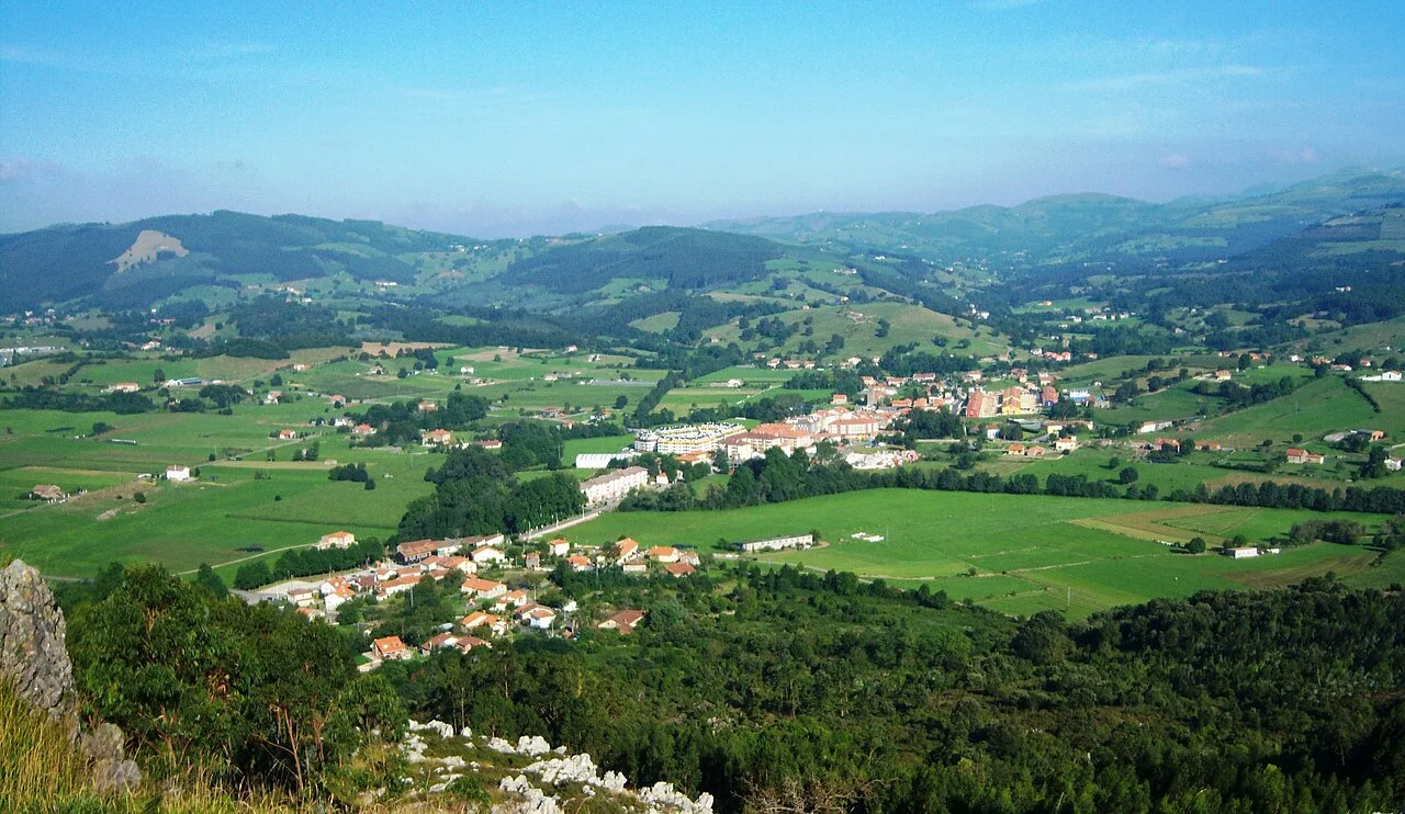 Paisaje con pueblo, campos verdes y montañas en el fondo desde Vizmaya.
