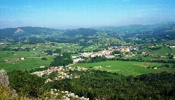 Landschaft mit Dorf, grünen Feldern und Bergen im Hintergrund von Vizmaya.