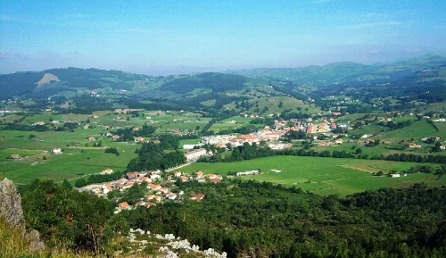 Paisaje con pueblo, campos verdes y montañas en el fondo desde Vizmaya.