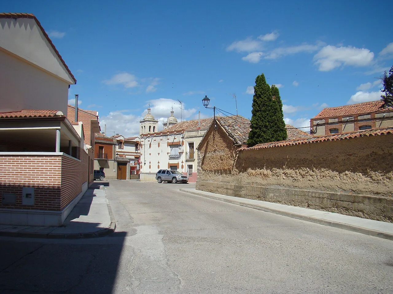 Streets with traditional houses and a church in the background in Cigales.