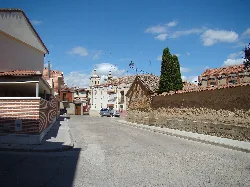 Streets with traditional houses and a church in the background in Cigales.