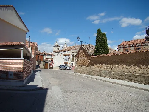 Calles con casas tradicionales y una iglesia en el fondo en Cigales.