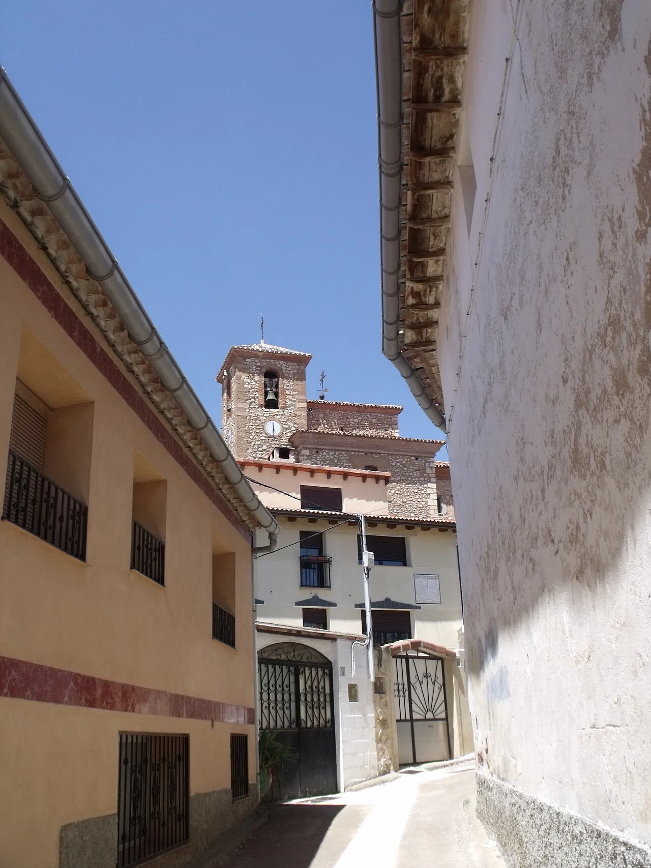 Calle estrecha con una iglesia en el fondo en Torre los Negros.