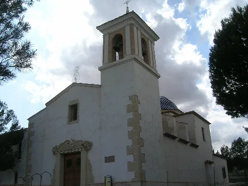 Iglesia blanca con torre y puerta de madera en Montealegre del Castillo.