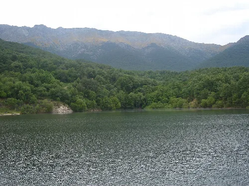 Blick auf einen Stausee, umgeben von Bergen und Bäumen bei Casavieja.
