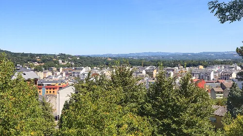 Blick auf die Stadt Sarria mit Gebäuden und Bäumen.
