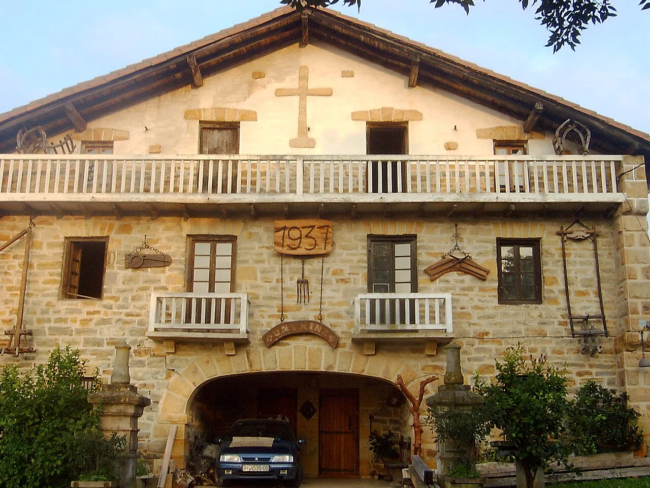 Stone building with wooden balconies and a cross on top.