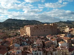 Castillo o fortaleza en lo alto de Mora de Rubielos con casas alrededor.