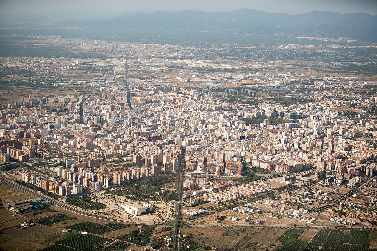 Vista aérea de una ciudad con muchos edificios y montañas al fondo.