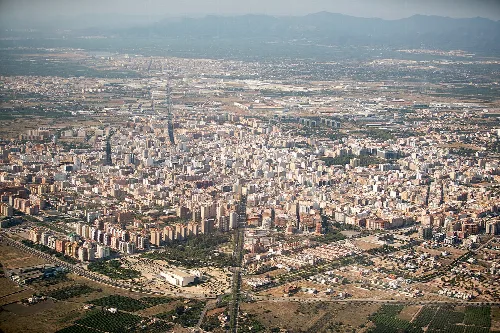 Vista aérea de una ciudad con muchos edificios y montañas al fondo.