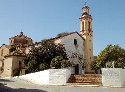 Iglesia blanca con torre y árboles en La Campana.