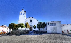 Plaza con iglesia blanca y árboles en Usagre, Badajoz.