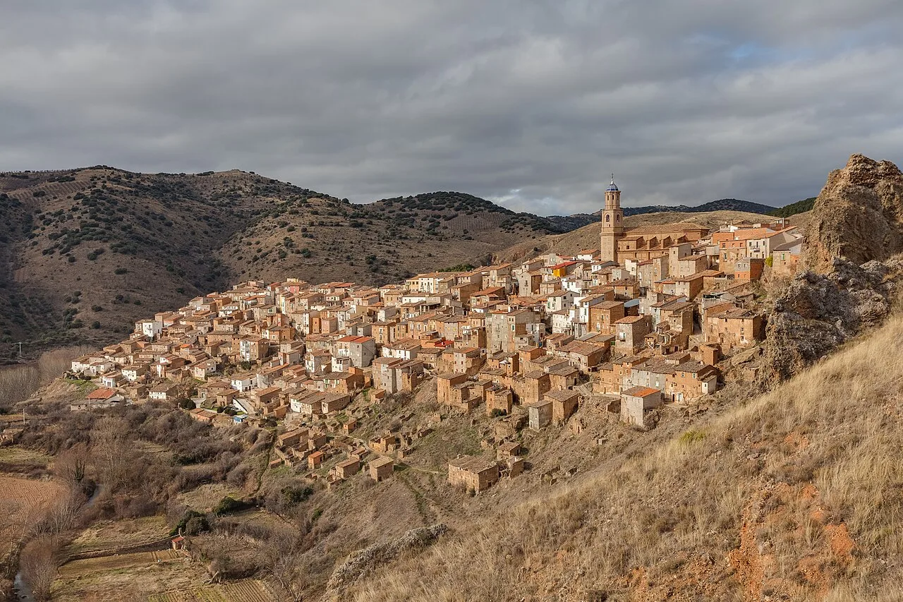 Panoramablick auf das Dorf Moros in Zaragoza, mit Häusern am Hang und einer Kirche oben.
