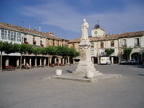 Square with statue in the center and traditional buildings in Villadiego