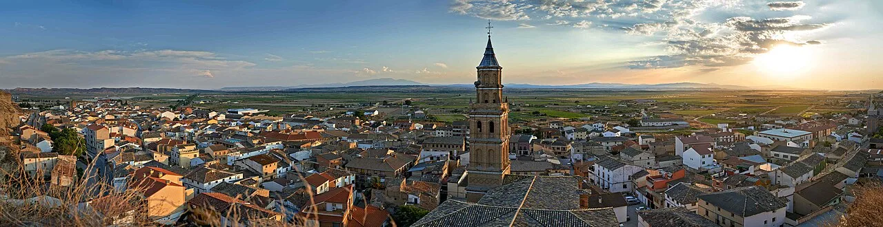 Panoramic view of Arguedas with church and traditional houses at sunset.