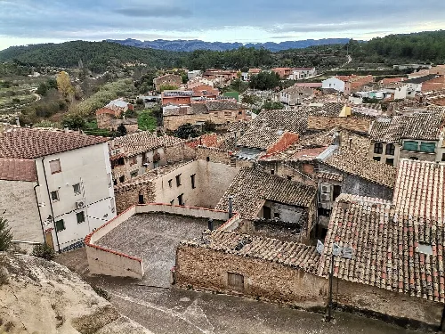 Panoramablick auf Arens de Lledó mit Dächern und Straßen in einer bergigen Landschaft.