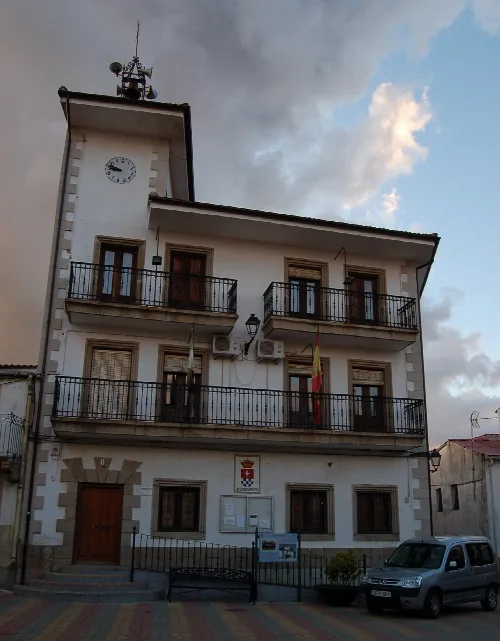 Weißes Gebäude mit Uhr und Flaggen an der Fassade