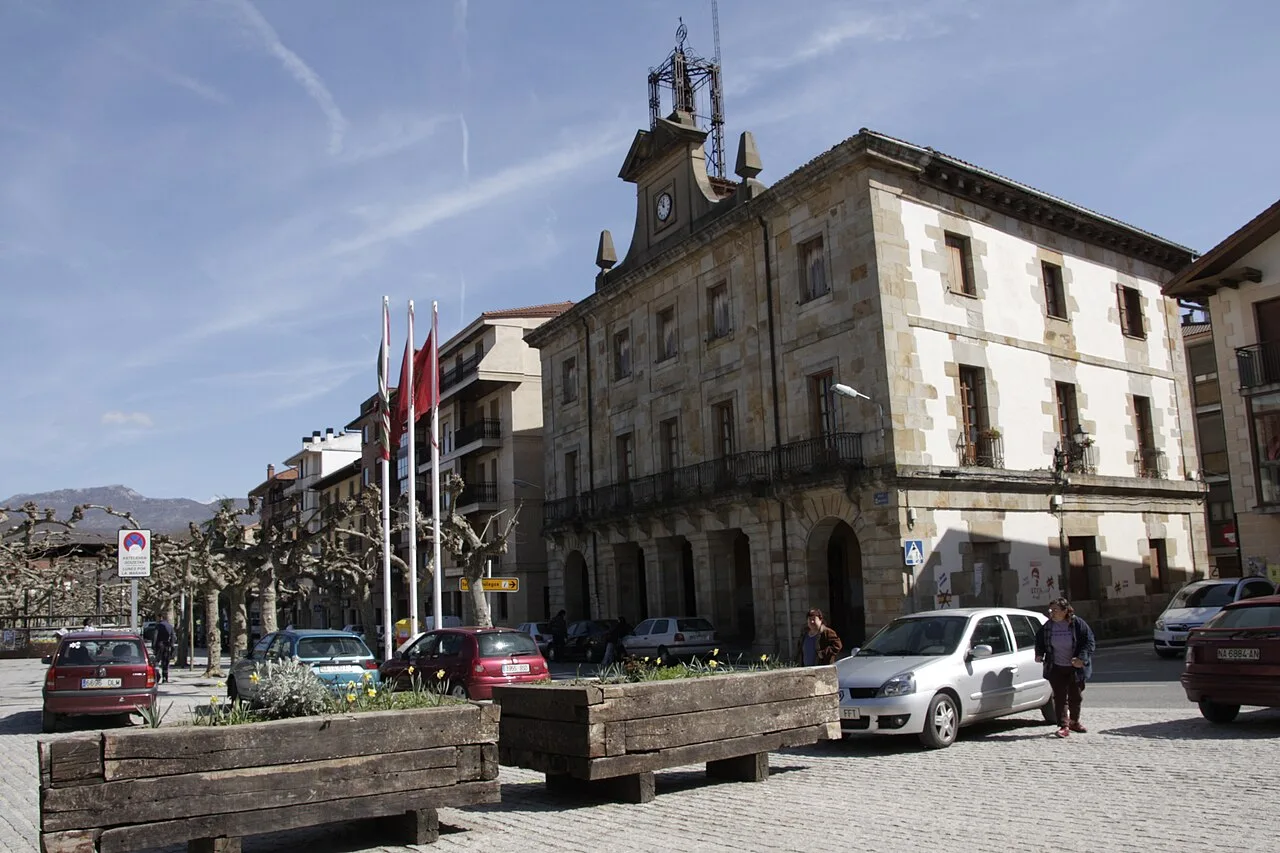 Edificio de estilo clásico con banderas en la plaza de Etxarri-Aranatz, Navarra.