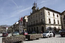 Edificio de estilo clásico con banderas en la plaza de Etxarri-Aranatz, Navarra.