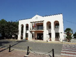 Domeño town hall building with arches and flag on the facade.