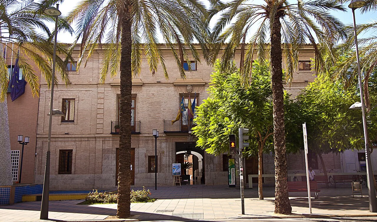 Edificio de Casa Vivanco con palmeras y árboles en la plaza.