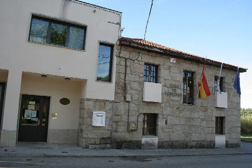 Steinernes Gebäude mit Flaggen an der Fassade und einem Schild, das Casa do Concello sagt.