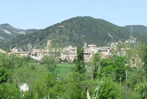 Stadt Salàs de Pallars mit Häusern und Kirche in einer Berglandschaft.