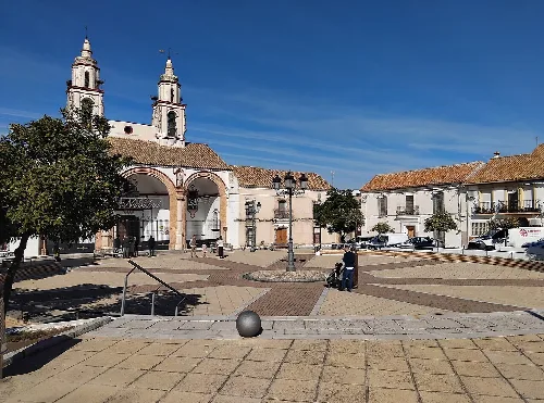 Platz mit Kirche und Turm in La Carlota, Córdoba, Spanien.
