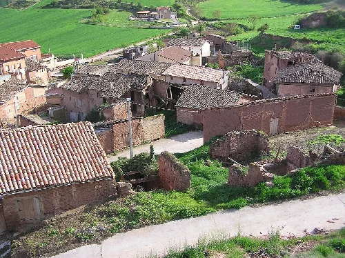 Alte Häuser und Ruinen in Bezares, La Rioja, mit grünen Hügeln