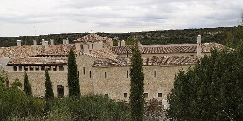 View of San Pelayo Monastery with stone walls and trees around.